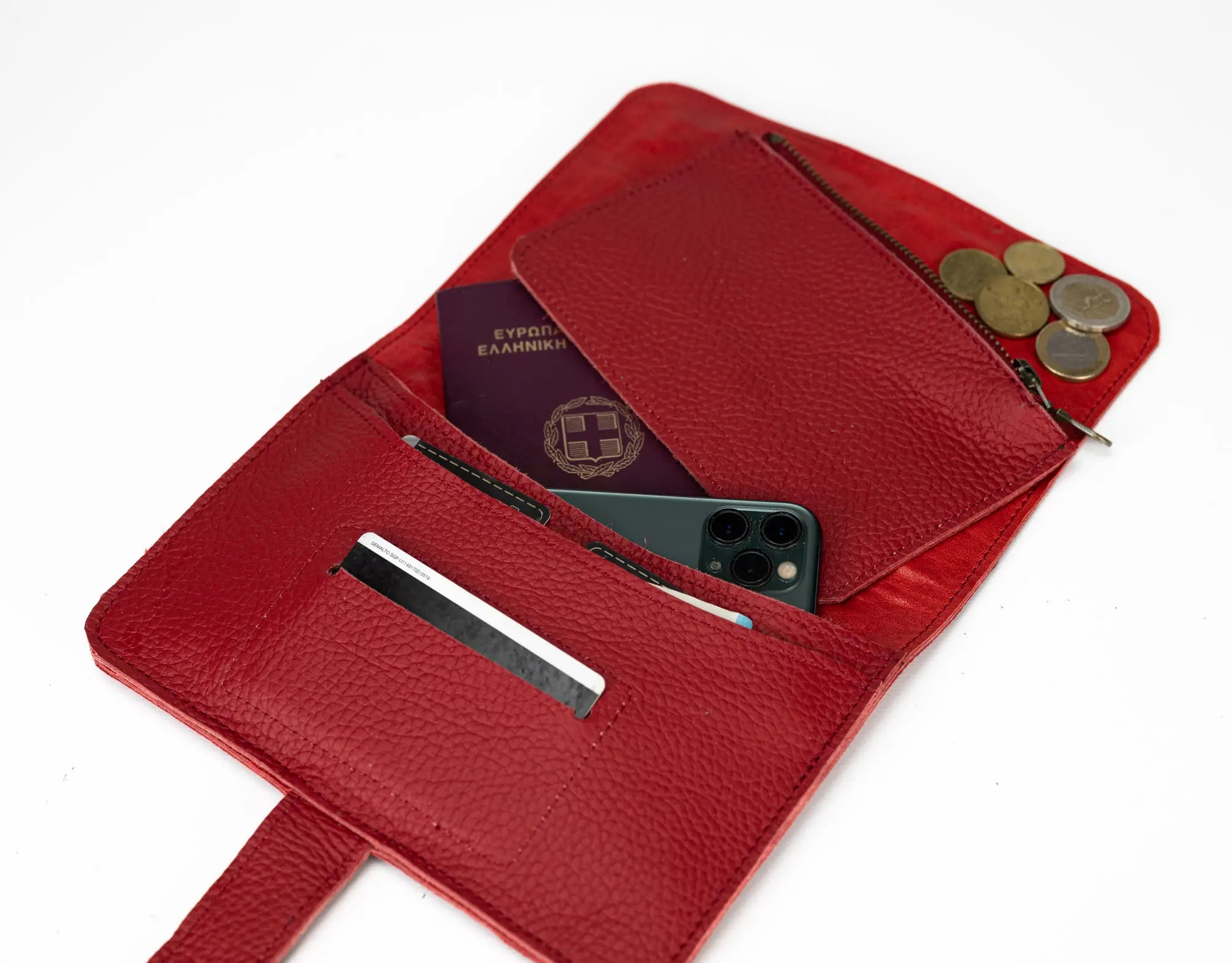 Red leather wallet with various items including a phone, coins, and a passport.
