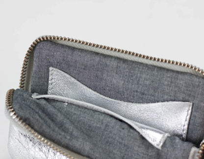 Close-up of a gray pouch with a silver lining on a light gray background
