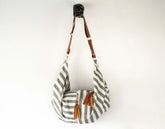 Striped bag with brown leather straps on a white background