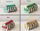 Four striped pouches with different colored zipper pulls on a light background