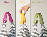 Three colorful handles on a striped bag with color labels above them.