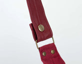 Red strap with gold hardware on a white background